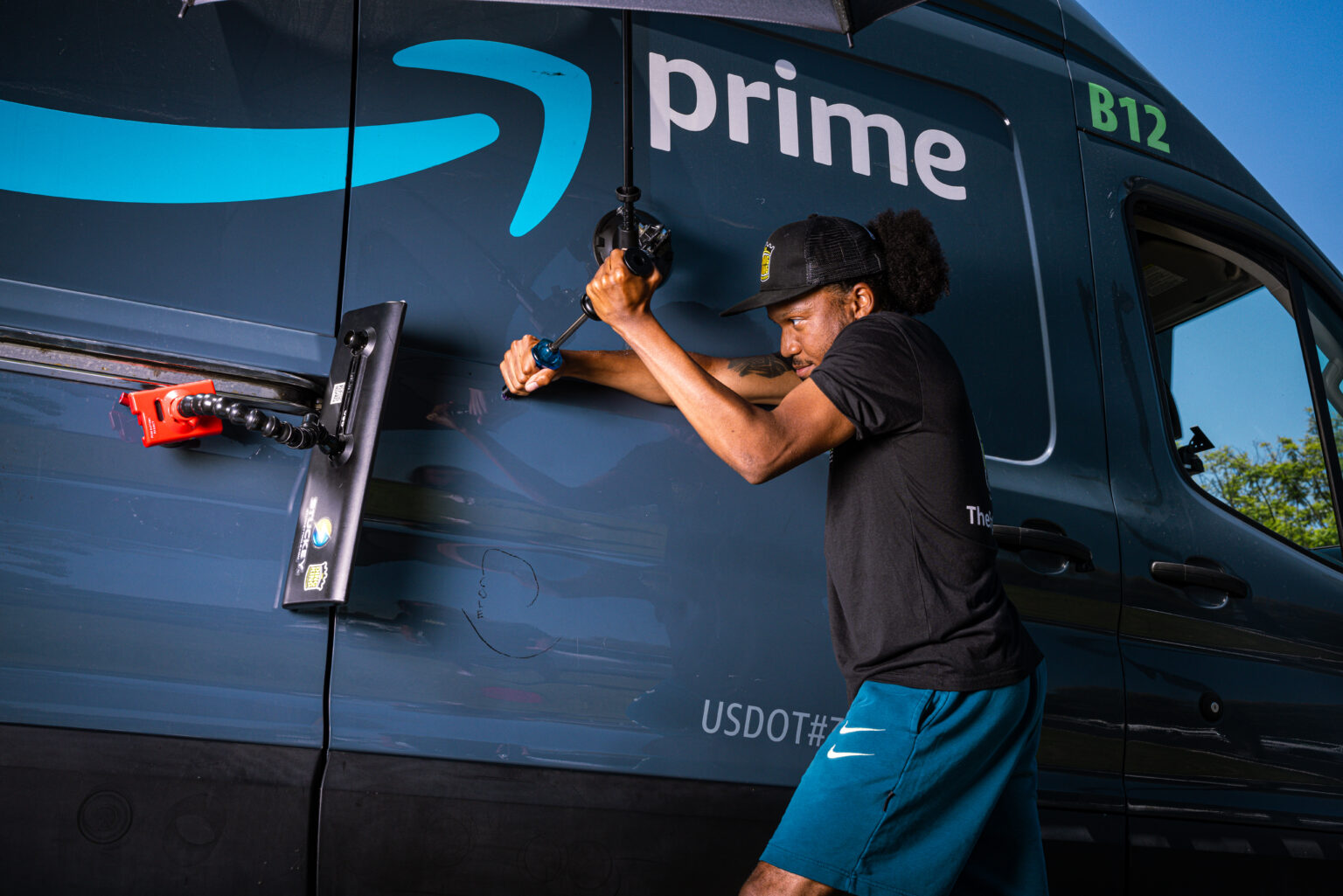 An FRS technician repairing a body panel on a commercial Amazon delivery van