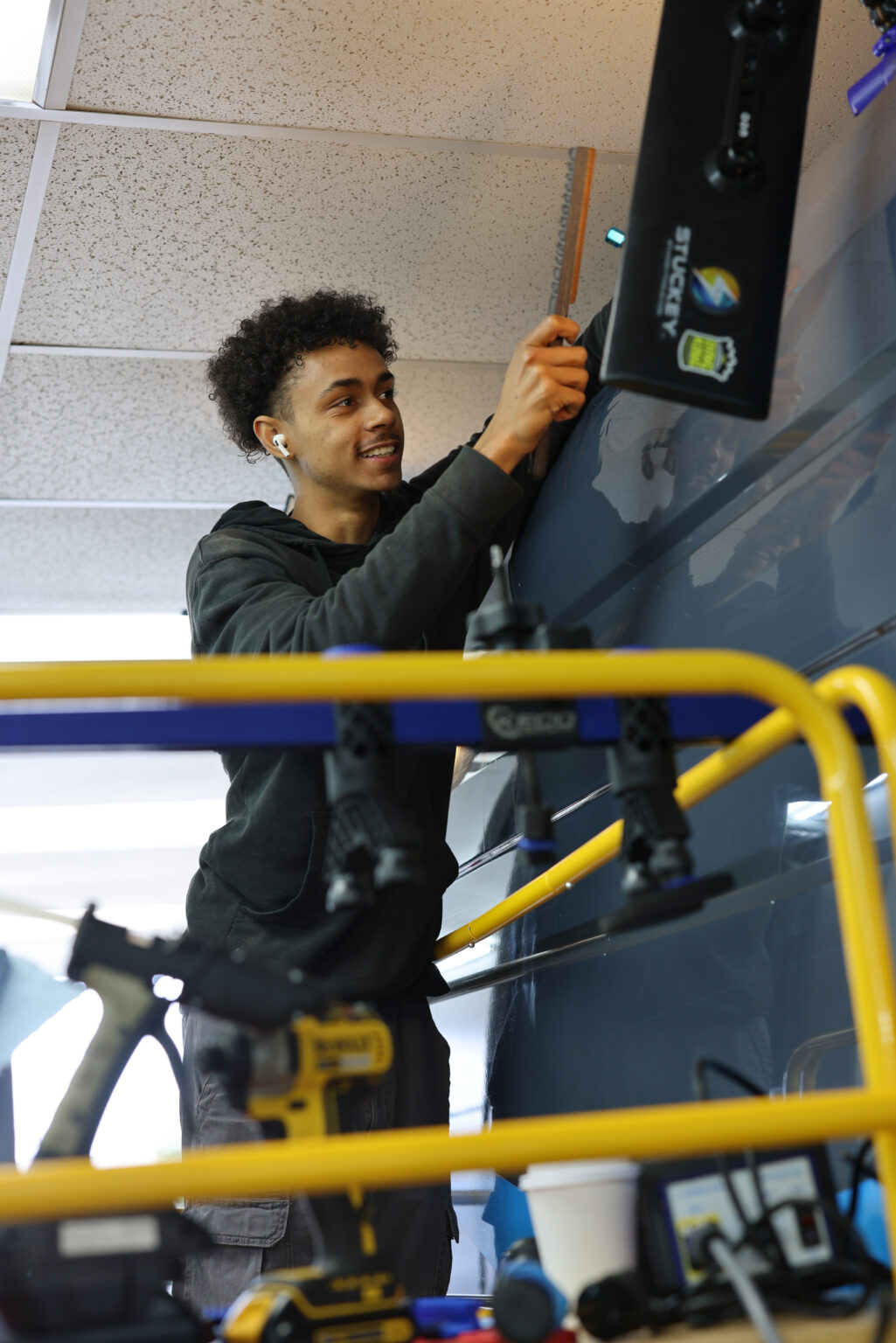 An FRS technician assessing a van body panel with paintless dent repair tooling
